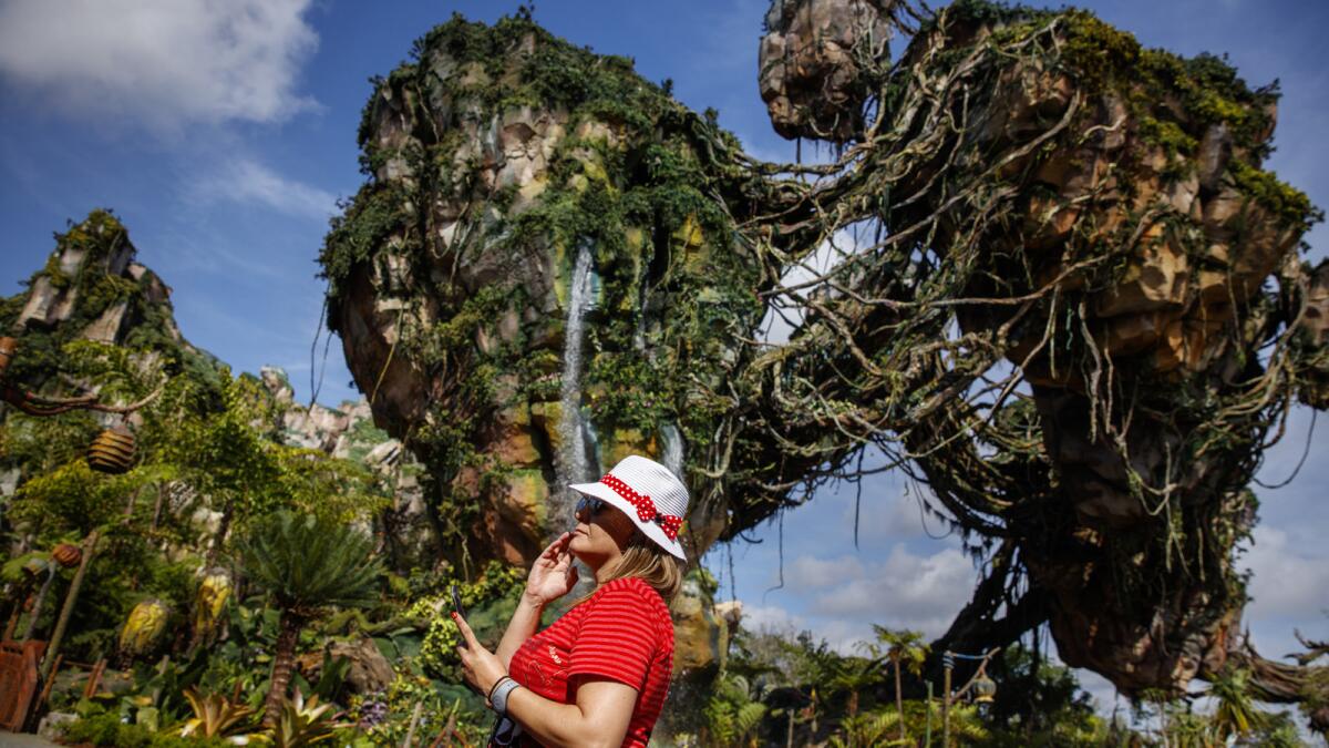 A woman walks past the floating mountains in Pandora - The World of Avatar.
