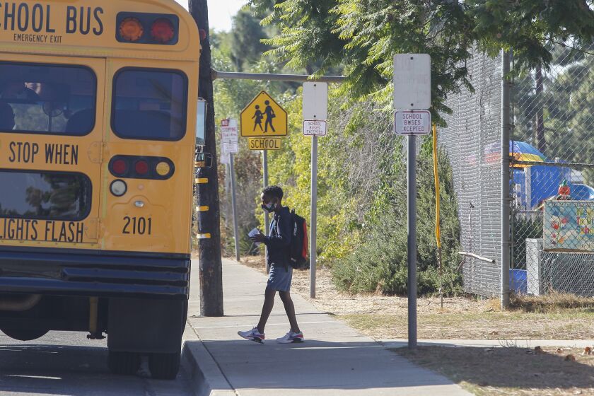 SAN DIEGO, CA - OCTOBER 13: A student boards the bus to go home after finishing his day, on the first day of in person learning at Lafayette Elementary School on Tuesday, Oct. 13, 2020 in San Diego, CA. (Eduardo Contreras / The San Diego Union-Tribune)