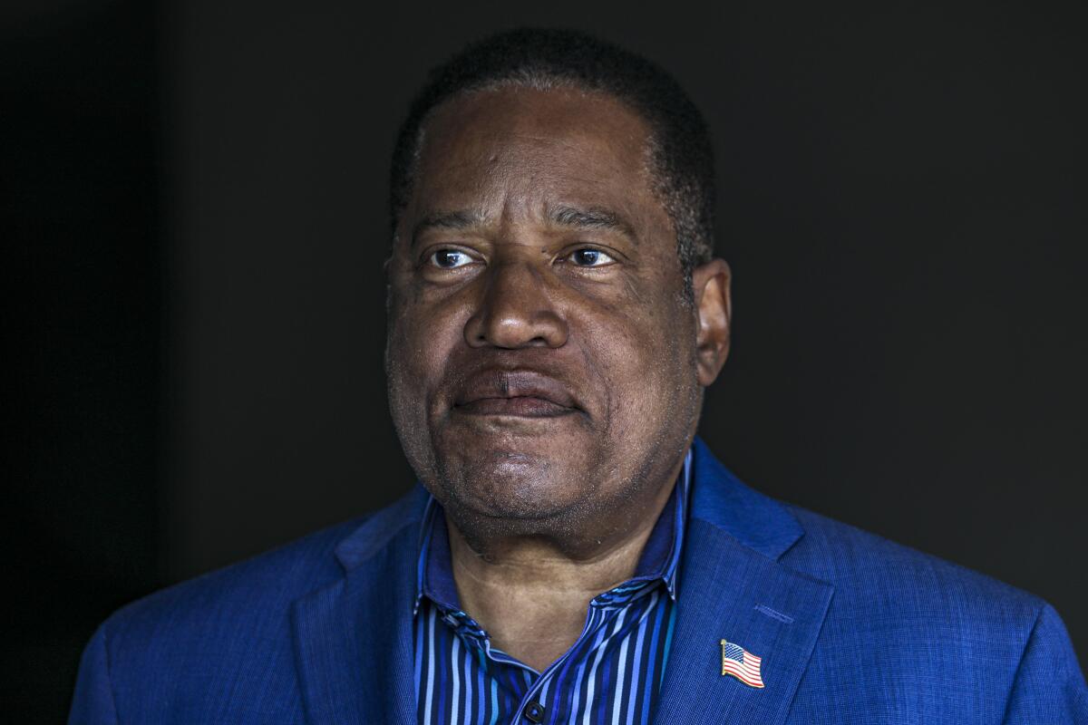 A closeup of Larry Elder in an open collar shirt and suit jacket.
