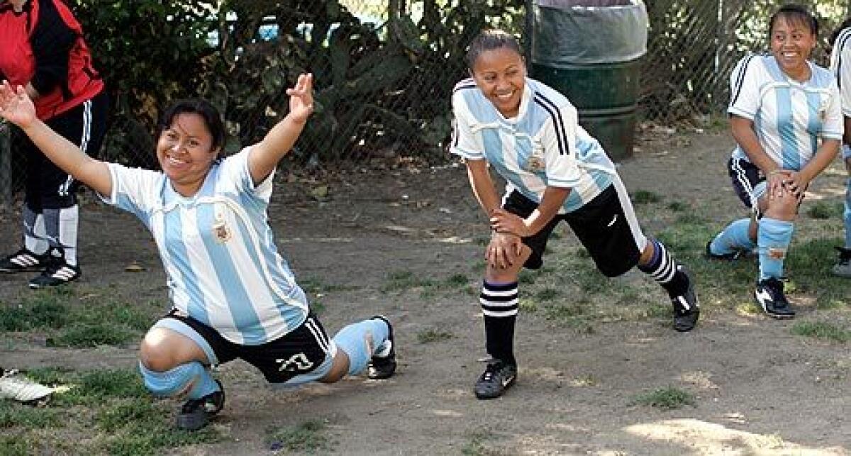 Celestina Lopez, 40, Elda Lopez, 30, and Francisca Lopez, 34, stretch out before a soccer game at MacArthur Park in Los Angeles. During the week, the sisters work in the garment industry. But on weekends, they play a game that was forbidden to them in Guatemala.