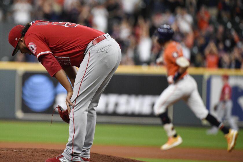 Los Angeles Angels starting pitcher Jaime Barria, left, reacts after giving up a two-run home run to Houston Astros' Carlos Correa, back right, during the first inning of a baseball game Friday, Sept. 20, 2019, in Houston. (AP Photo/Eric Christian Smith)