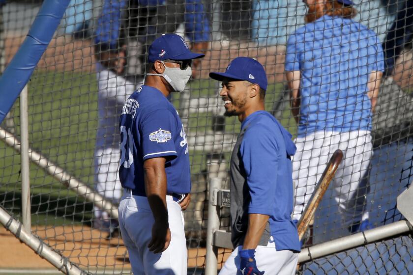 LOS ANGELES, CALIF. - JULY 3, 2020. Dodgers right fielder Mookie Betts chats with manager Dave Roberst during practice at Dodger Stadium on Friday, July 3, 2020. (Luis Sinco/Los Angeles Times)