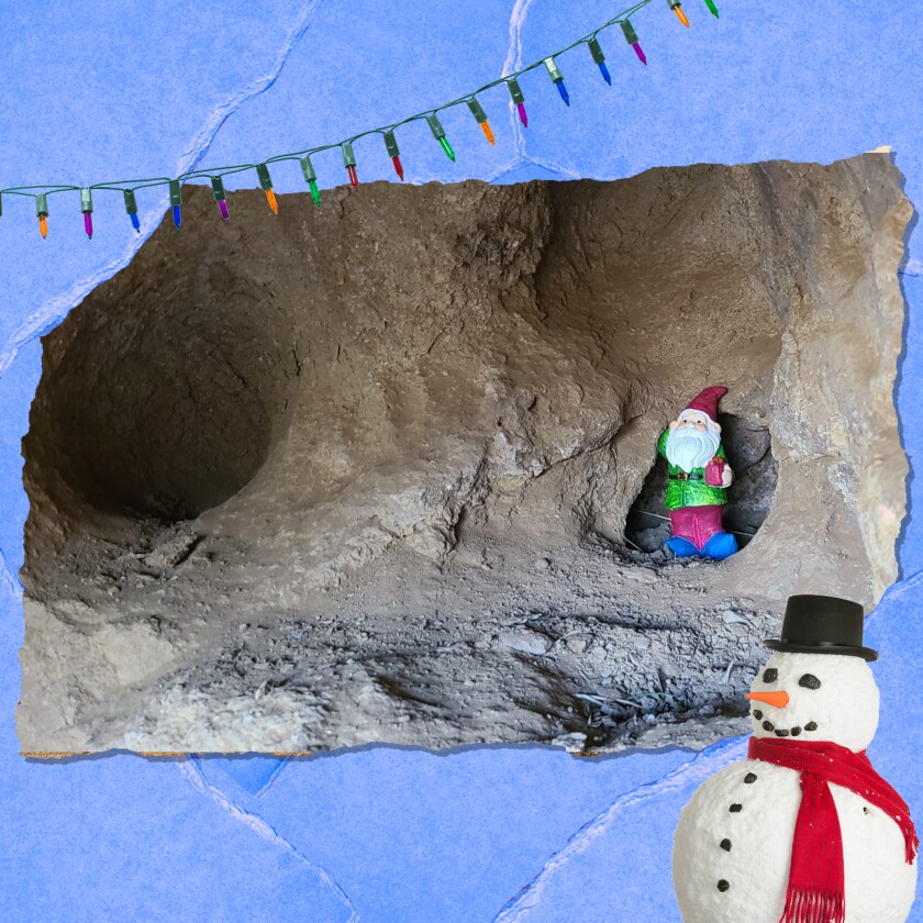 A small gnome figurine with a red cap and white beard sits near the opening to a cave.