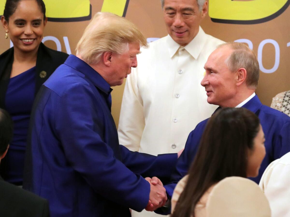 President Trump shakes Russian President Vladimir Putin's hand before a group photo session at the APEC summit in Vietnam.