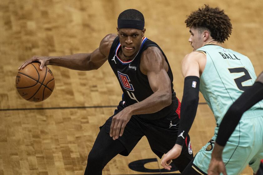 Los Angeles Clippers guard Rajon Rondo (4) brings the ball up court while guarded by Charlotte Hornets guard LaMelo Ball (2) during the first half of an NBA basketball game in Charlotte, N.C., Thursday, May 13, 2021. (AP Photo/Jacob Kupferman)