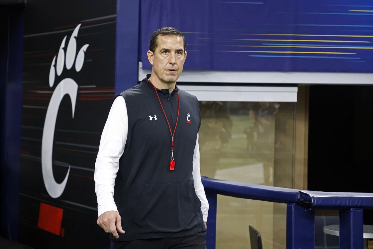 FILE - Cincinnati coach Luke Fickell walks onto the field before the Cotton Bowl NCAA College Football Playoff semifinal game against Alabama, Friday, Dec. 31, 2021, in Arlington, Texas. Fickell has received a two-year contract extension through 2028 and a raise to $5 million per year after leading the Bearcats to the College Football Playoff. The university board of trustees approved the contract extension Tuesday, Feb. 22, 2022, also increasing the football staff salary pool to $5.2 million per year. (AP Photo/Michael Ainsworth, File)