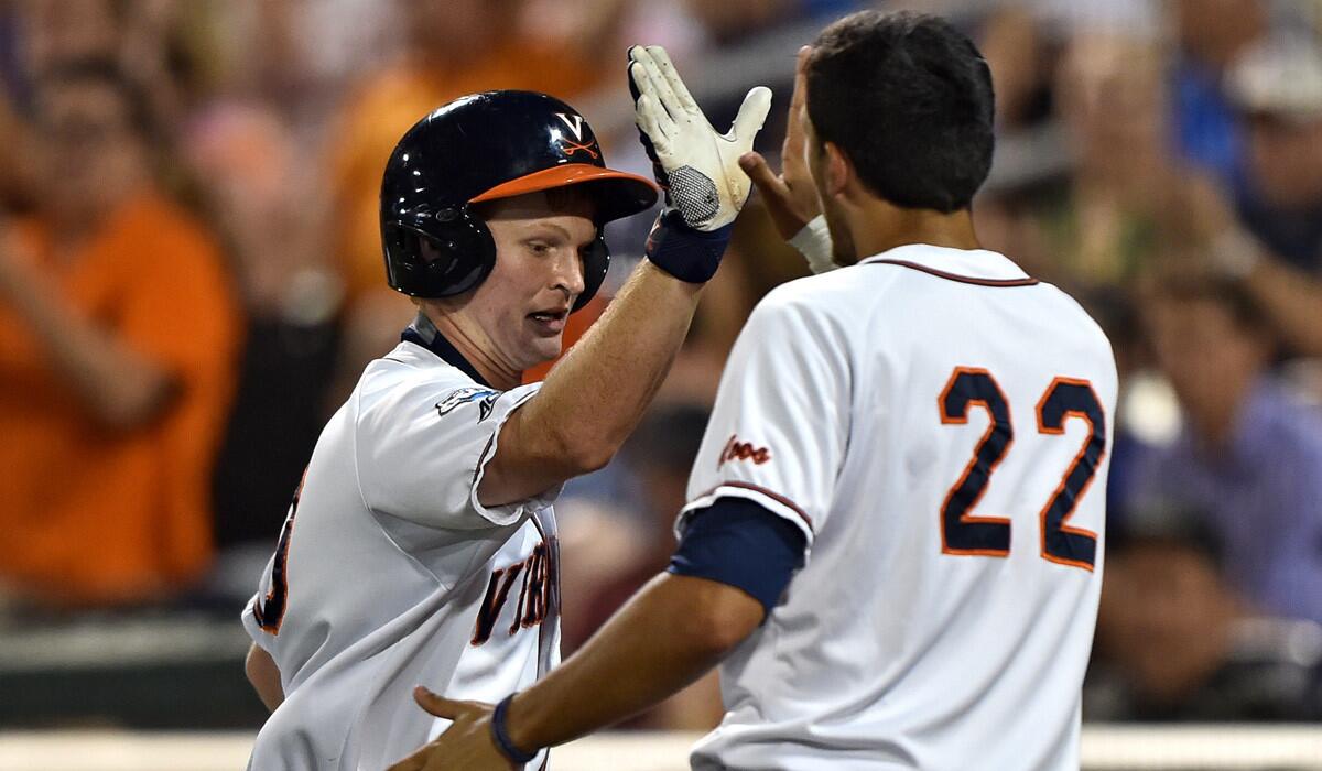 Virginia's Pavin Smith celebrates with Daniel Pinero after scoring against Vanderbilt in the sixth inning during game two of the College World Series finals on Tuesday. Virginia won 3-0 and has forced a Game 3.