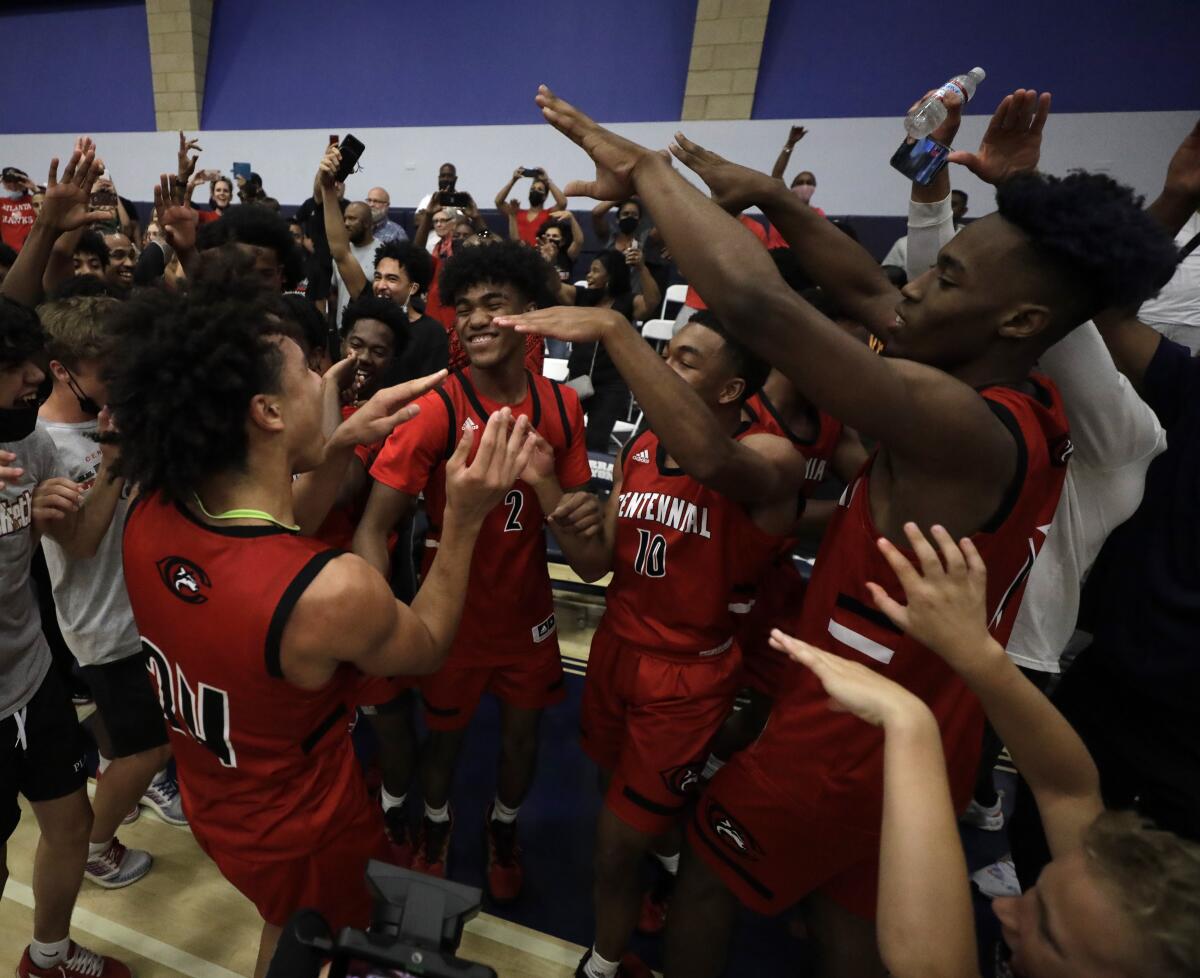 Corona Centennial players raise their hands to celebrate a win