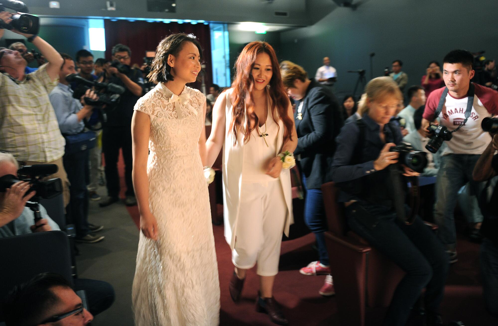 Xu Na, left, and Xue Mengyao walk toward the stage to be married by West Hollywood Mayor Lindsey Horvath on June 9, 2015.