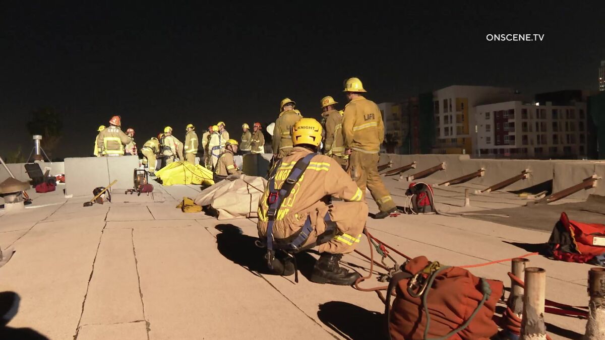 Firefighters and equipment on the roof of a building in the dark