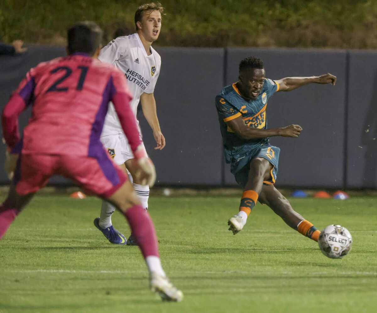 San Diego Loyal's Tumi Moshobane kicks ball toward LA Galaxy II's goalie Richard Sanchez in Loyal's home opener last month.