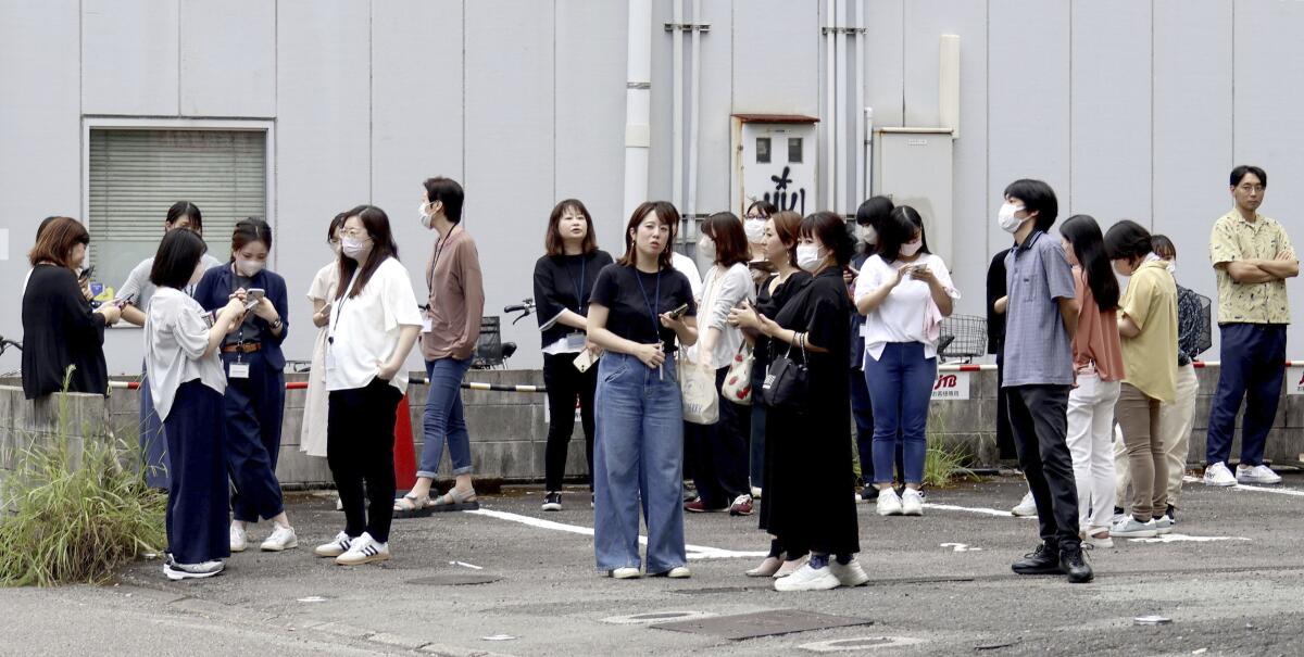 People stand outside a building following an earthquake in Miyazaki, western Japan.