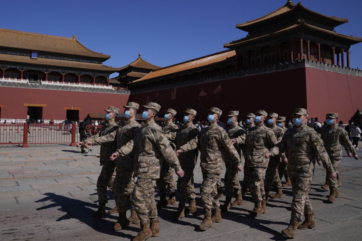 Chinese military personnel march past the Forbidden City on Saturday, March 5, 2022, in Beijing. China announced that it is raising its defense spending in 2022 by 7.1% to $229 billion, up from a 6.8% increase the year before. (AP Photo/Ng Han Guan)