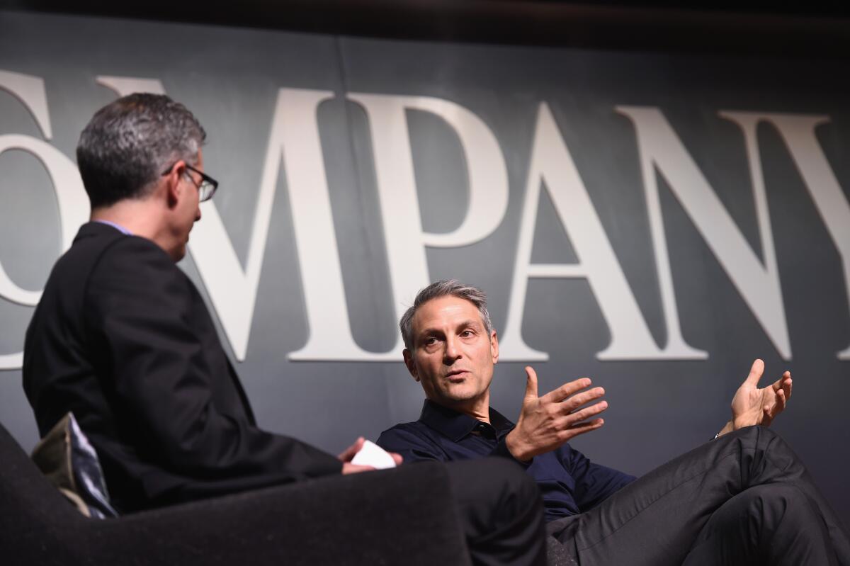 Two seated men speaking onstage 