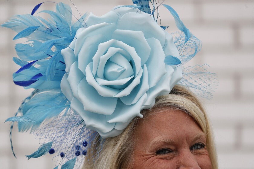 o femeie poartă o pălărie în timpul celei de-a 145-a alergări a Cursa de cai Kentucky Derby la Churchill Downs pe 4 mai 2019.