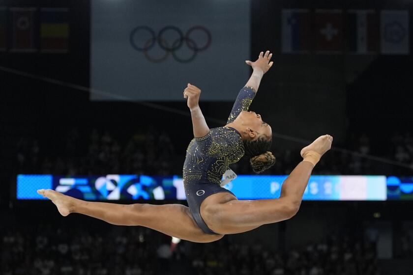 la brasileña Rebeca Andrade durante su actuación en la barra de equilibrio durante la final por equipos de la gimnasia artística en la Arena Bercy en los Juegos Olímpicos de París el martes 30 de julio del 2024. (AP Foto/Abbie Parr)