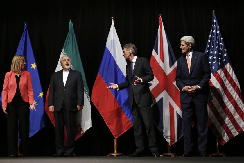 European Union High Representative for Foreign Affairs and Security Policy Federica Mogherini, left, Iranian Foreign Minister Mohammad Javad Zarif, British Foreign Secretary Philip Hammond and U.S. Secretary of State John F. Kerry gather on stage for a group picture after reaching a deal on Iran's nuclear program in Vienna on Tuesday.