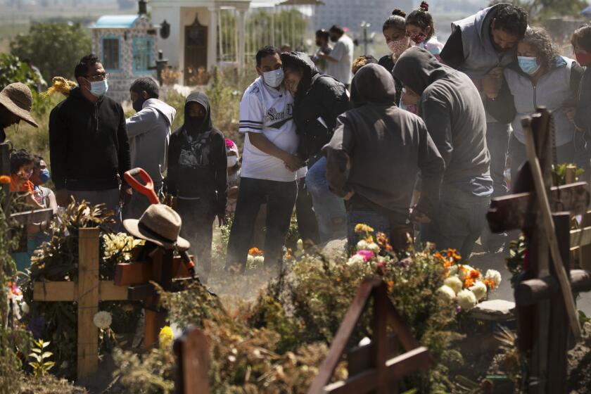 Parientes entierran a Isaac Nolasco, quien falleció por motivos al parecer no relacionados con el COVID-19, en una sección del panteón municipal de Valle de Chalco en medio de la pandemia de coronavirus, en las afueras de Ciudad de México, el domingo 25 de octubre de 2020. (AP Foto/Marco Ugarte)