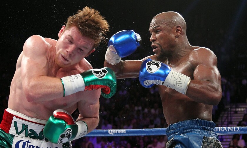 Floyd Mayweather Jr., right, delivers a blow to Saul "Canelo" Alvarez during their fight on Saturday night. Mayweather won by decision, but judge C.J. Ross scored it a draw.