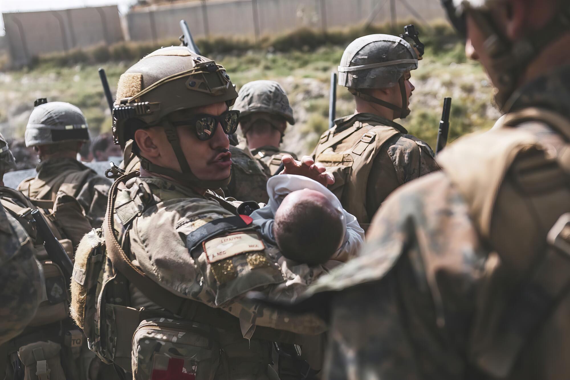 A U.S. Marine holds an infant in his arms