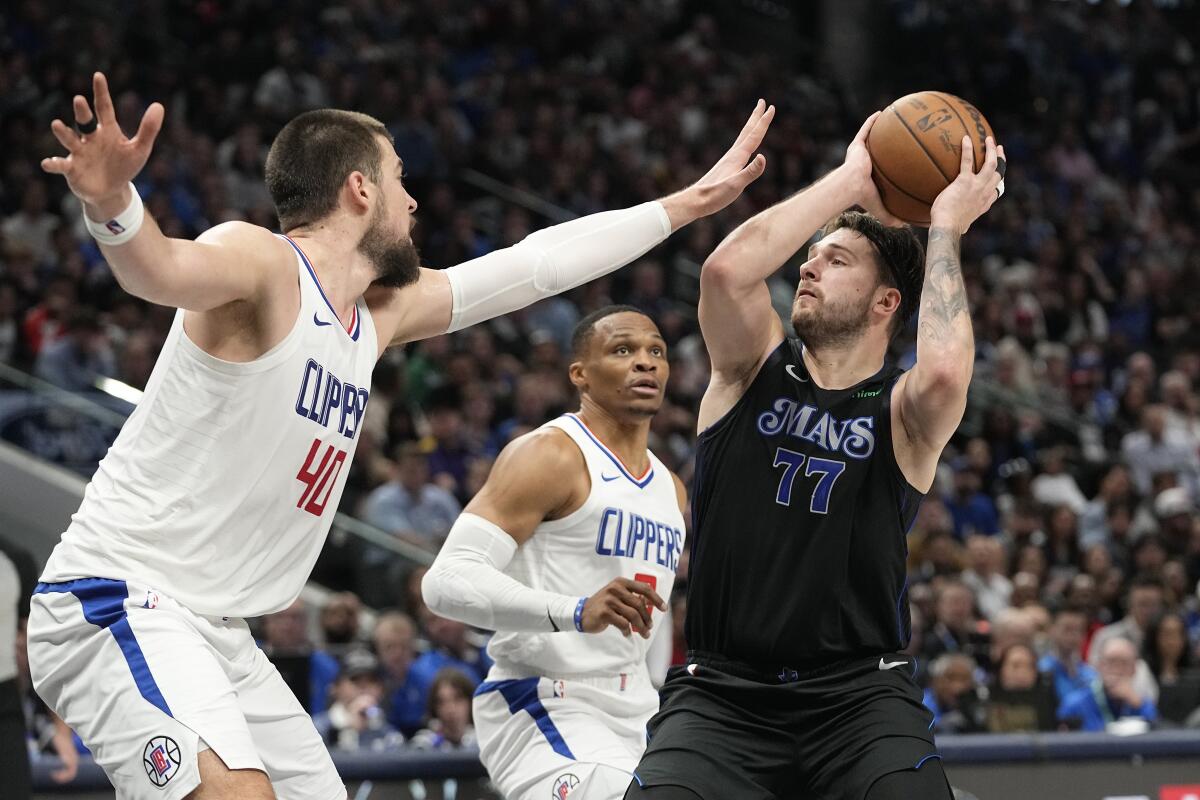 Ivica Zubac and Russell Westbrook try to stop Luka Doncic from throwing the ball.