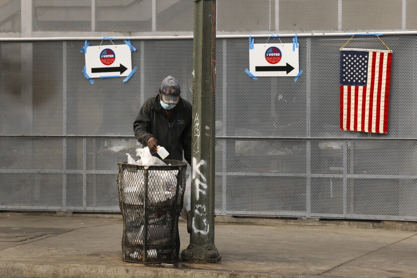 A man looks through the garbage outside the polling station a downtown L.A. community center. 