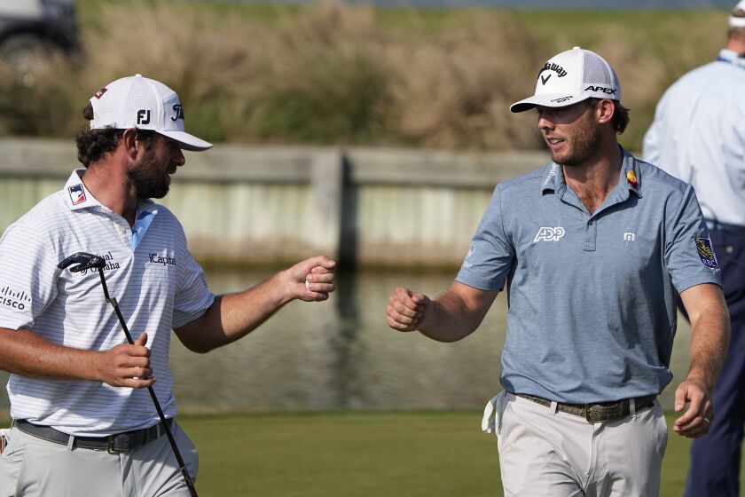 Sam Burns, right, is congratulated by Cameron Young after Burns defeated him in the final match at the Dell Technologies Match Play Championship golf tournament in Austin, Texas, Sunday, March 26, 2023. Michael Dell, left, presented the trophy. (AP Photo/Eric Gay)
