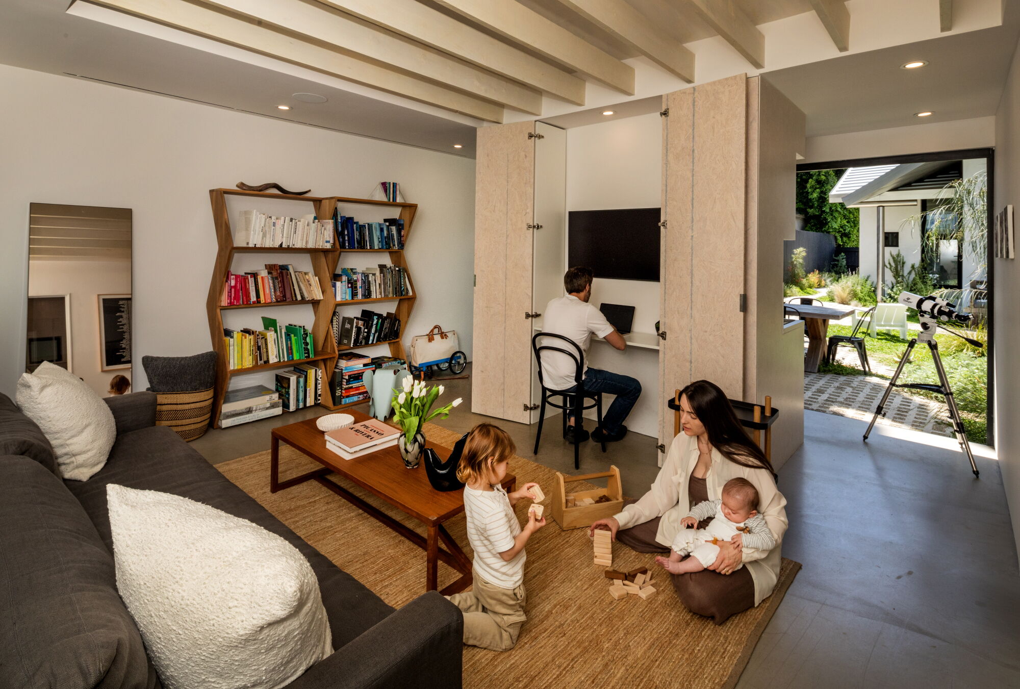 The family plays in the living room of the ADU while Hochberg works from home.