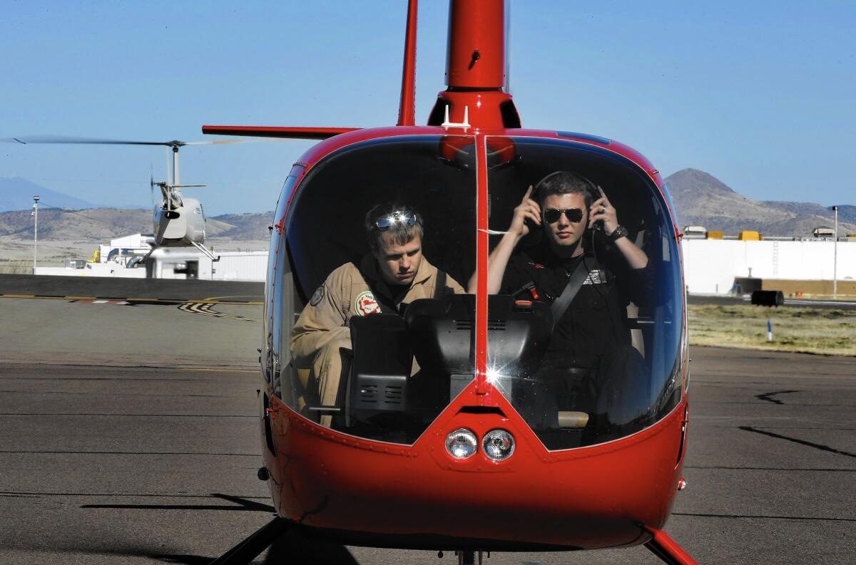 Student Sam Mills, left, gets a lesson from Ben Lewis in February at the helicopter training program at Yavapai Community College in Prescott, Ariz. A month later, the U.S. government ordered the program to stop enrolling new veterans.