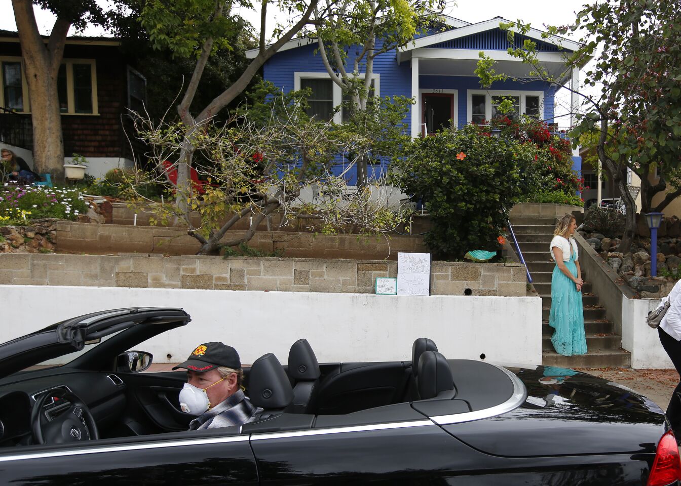 Ken Moser, of Mira Mesa, got a front row parking spot to watch opera singer Victoria Robertson perform from the porch of her North Park home on April 19, 2020. For the second week in a row, Robertson performed for 15 minutes to a crowd, who kept their distance from each other on the street below.