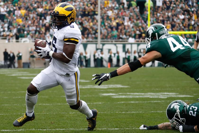 Michigan's Jabrill Peppers, left, runs for a first quarter touchdown past Michigan State's Grayson Miller on Saturday.