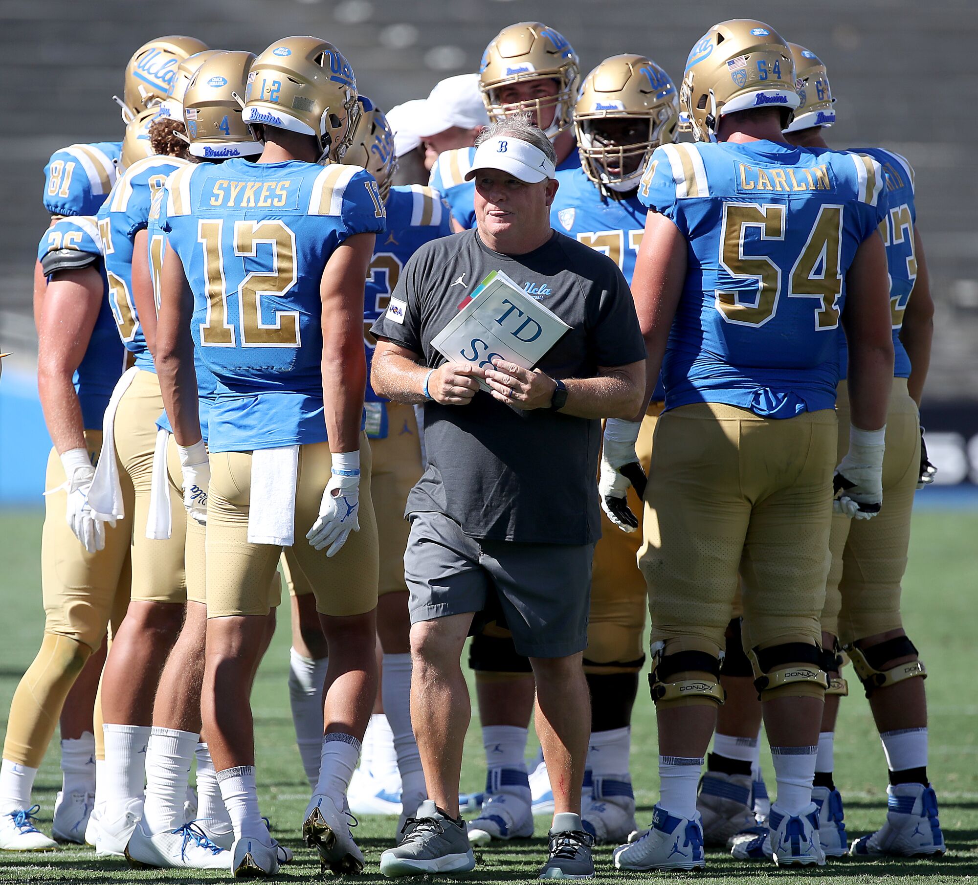 UCLA coach Chip Kelly huddles with players during a timeout in the fourth quarter.