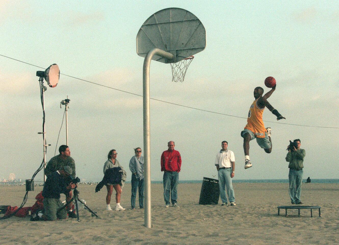 An airborne Kobe Bryant goes for a dunk while shooting a commercial.