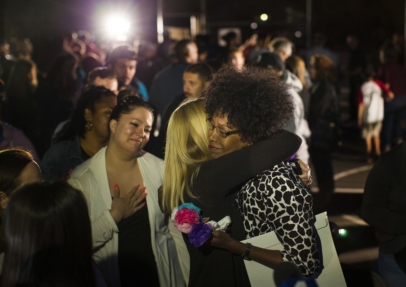 North Park Elementary School Principal Yadira Downing is comforted after the candlelight prayer vigil on the school's playground.