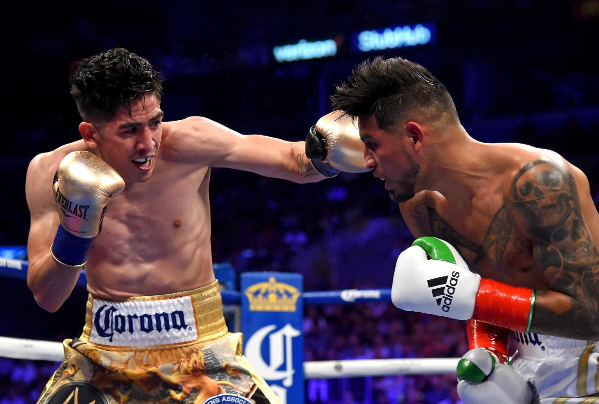 Leo Santa Cruz (gold shorts) battles to defeat Abner Mares (white shorts) in their WBA Featherweight Title & WBC Diamond Title fight at Staples Center on June 9.