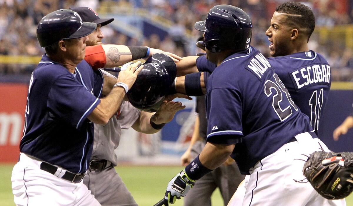 Rays shortstop Yunel Escobar, right, and Red Sox outfielder Jonny Gomes, back left, are separated by players and coaches after getting into a scuffle during their game Sunday.