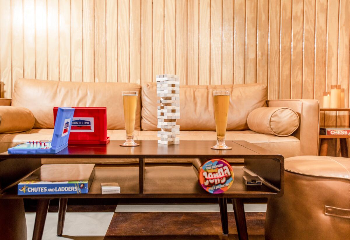A photo of beers and games like Jenga on a tabletop in the lounge area of Nostalgia Bar & Lounge.