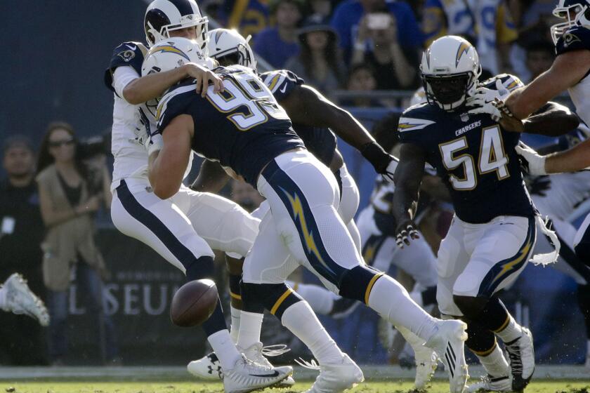 Los Angeles Rams quarterback Jared Goff, left, fumbles as he is hit by Los Angeles Chargers defensive end Joey Bosa (99) during the first half of a preseason NFL football game Saturday, Aug. 26, 2017, in Los Angeles. (AP Photo/Jae C. Hong)