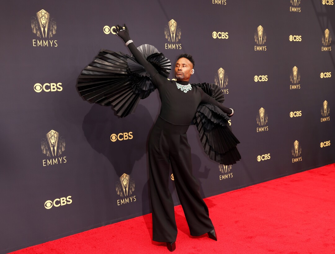 Billy Porter raises his arm on the red carpet.