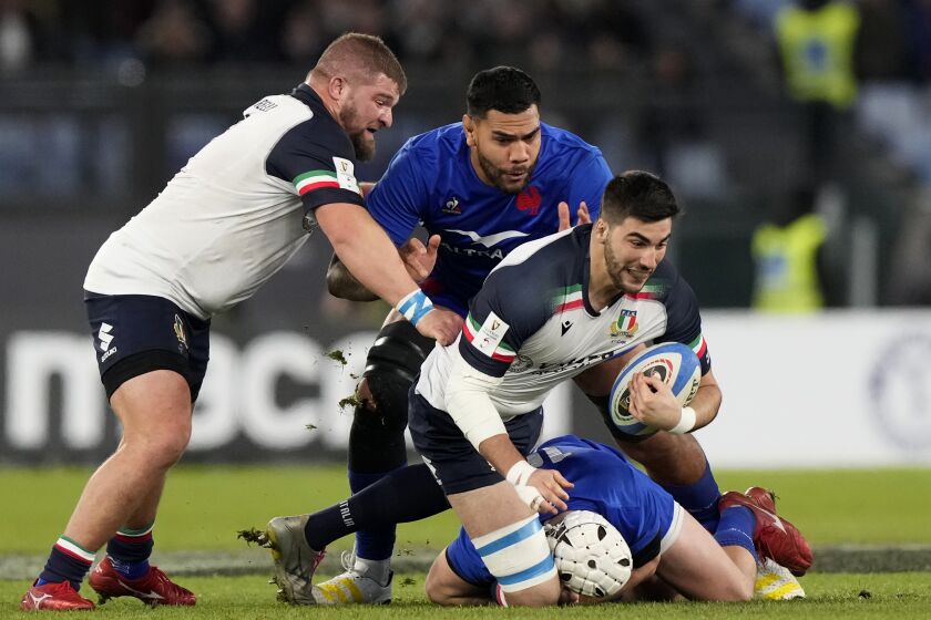 Italy's Edoardo Iachizzi, front, holds the ball as he is tackled by Italy's players during the Six Nations rugby union international match between Italy and France, at Rome's Olympic Stadium, Italy, Sunday, Feb. 5, 2023. (AP Photo/Andrew Medichini)