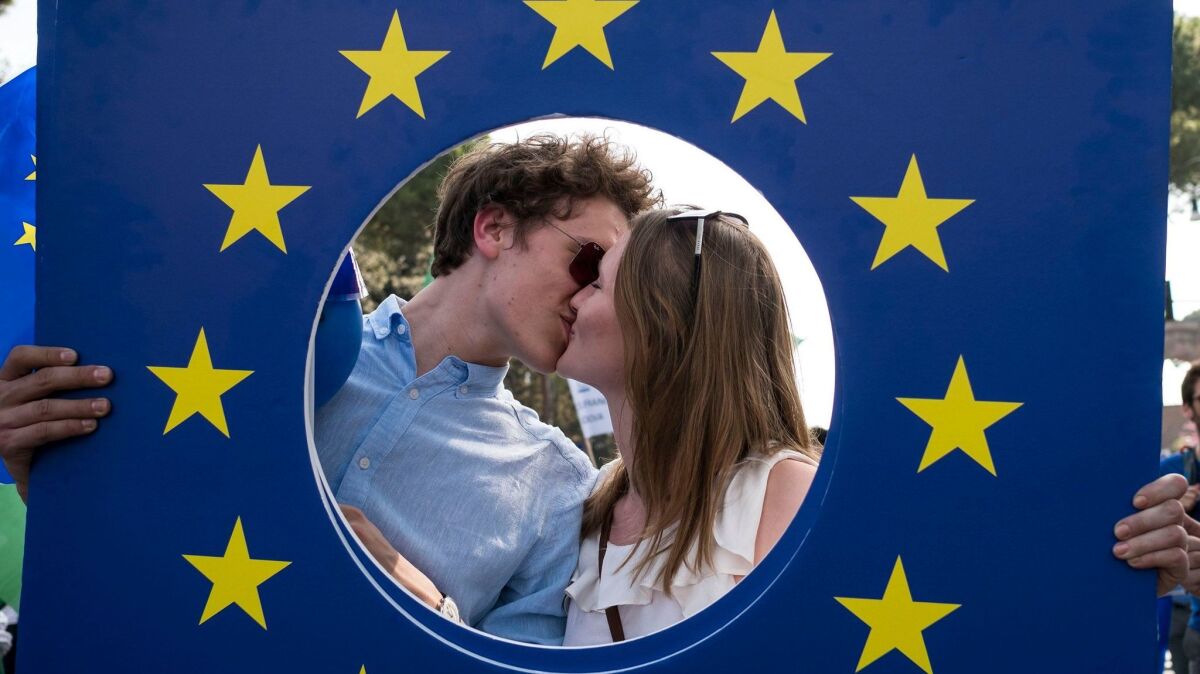 A couple kisses within a frame of the European Union logo during a rally on March 25, 2017, to support the EU on the 60th anniversary of the signing the Treaty of Rome in Italy. (Antonello Nusca / European Pressphoto Agency)
