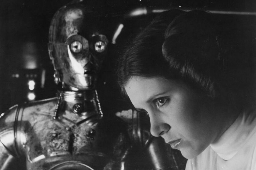 Carrie Fisher as Princess Leia with C3PO in the 1977 released of Star Wars by 20th Century Fox.