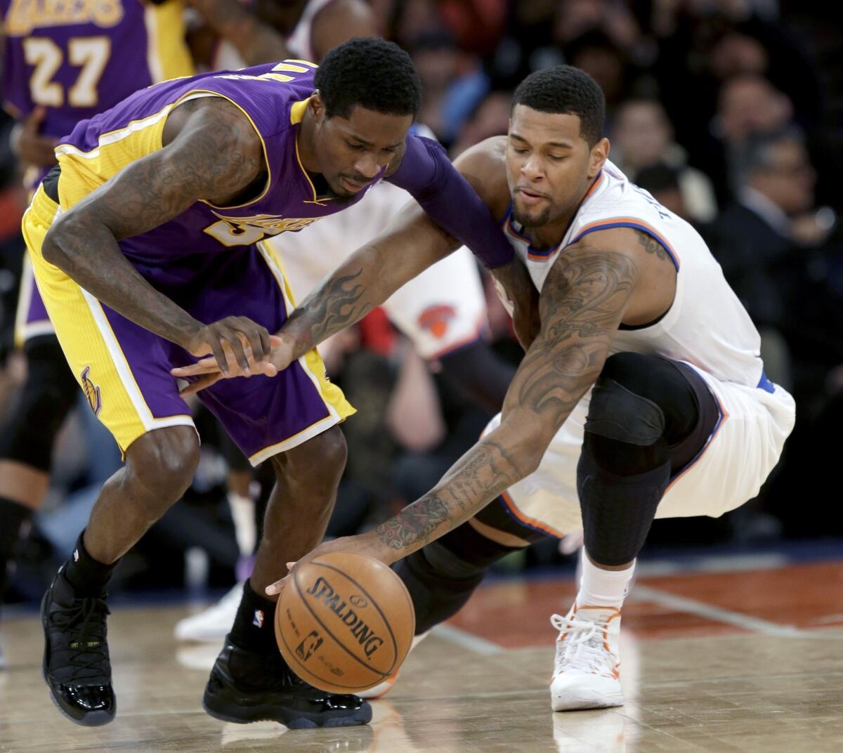 Lakers guard Manny Harris, left, and Knicks forward Jeremy Tyler chase after a loose ball in the second half of a game on Jan. 26. Tyler signed a free-agent contract Tuesday with the Lakers.