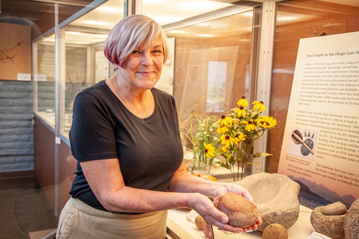 Cindy Stankowski, executive director of the San Diego Archaeological Center, holds a grinding stone from a local Native American archaeological site.