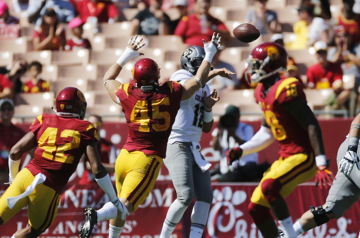 Trojans defensive end Porter Gustin (45) tries to deflect a pass from Buffaloes quarterback Steven Montez in the first half.