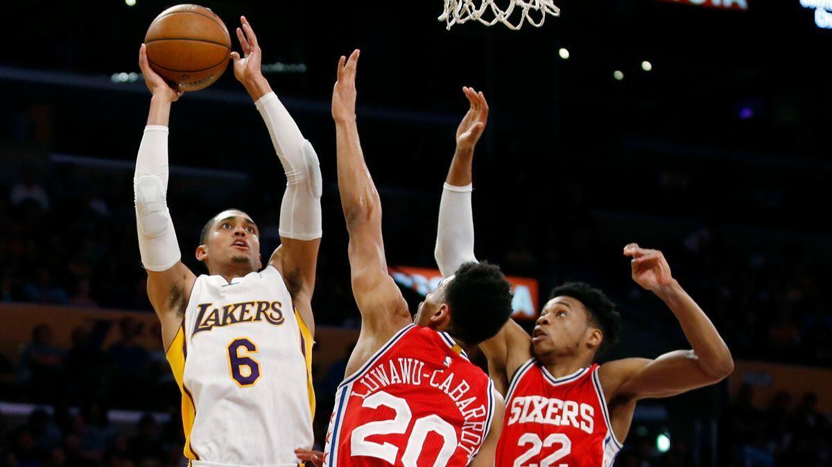 Lakers guard Jordan Clarkson (6) shoots over Philadelphia 76ers guard Timothe Luwawu-Cabarrot (20) and forward Richaun Holmes (22) during the first half Sunday.