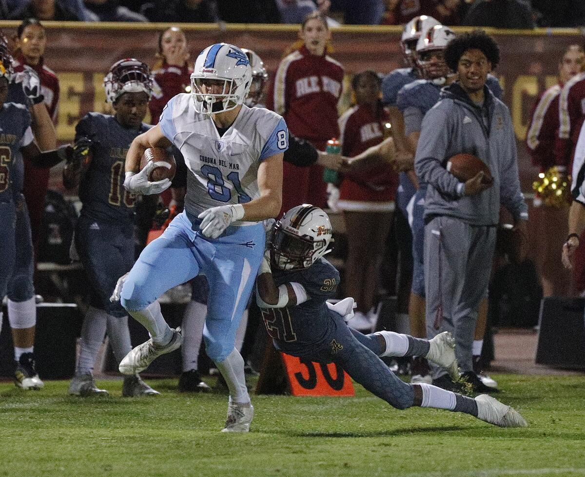 Corona del Mar's Mark Redman drags Alemany's Elijah Gipson after catching a pass for a first down in a CIF Southern Section Division 3 semifinal game in Mission Hills on Friday.