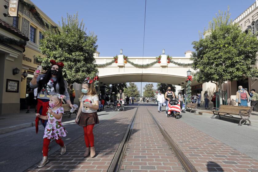 ANAHEIM, CA - NOVEMBER 19: Visitors walk down Buena Vista Street at Disney California Adventure which opened to the public on Thursday, Nov. 19, 2020 in Anaheim, CA but without rides. There were plenty of dining and shopping opportunities. (Myung J. Chun / Los Angeles Times)