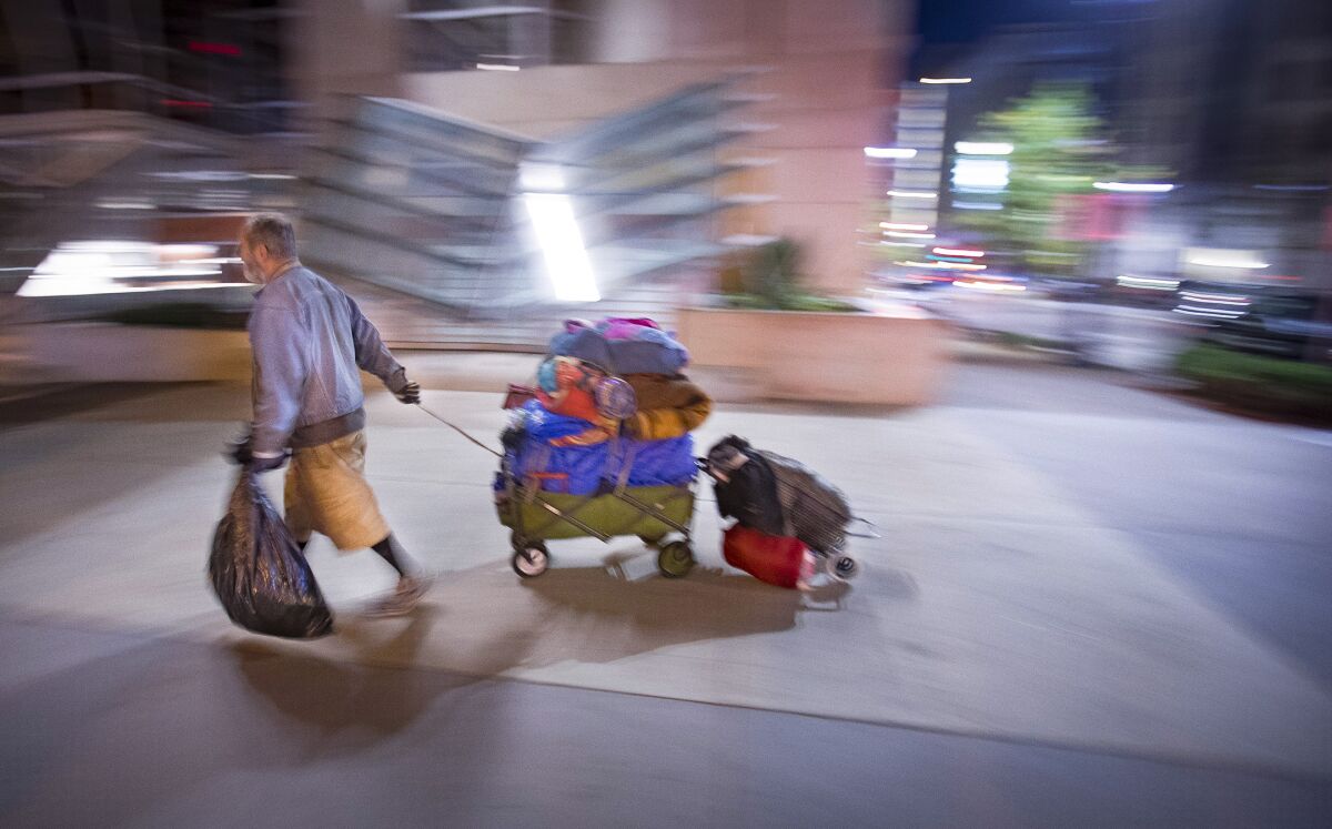 A homeless man walks near the San Diego Central Library in East Village.