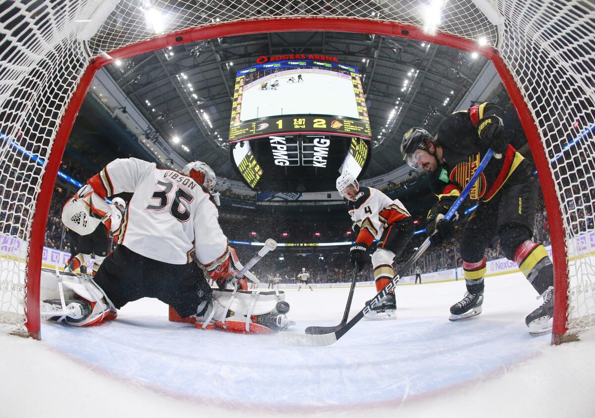 Ducks goaltender John Gibson stops a shot in front of Ducks defenseman Cam Fowler during the Vancouver Canucks' win.